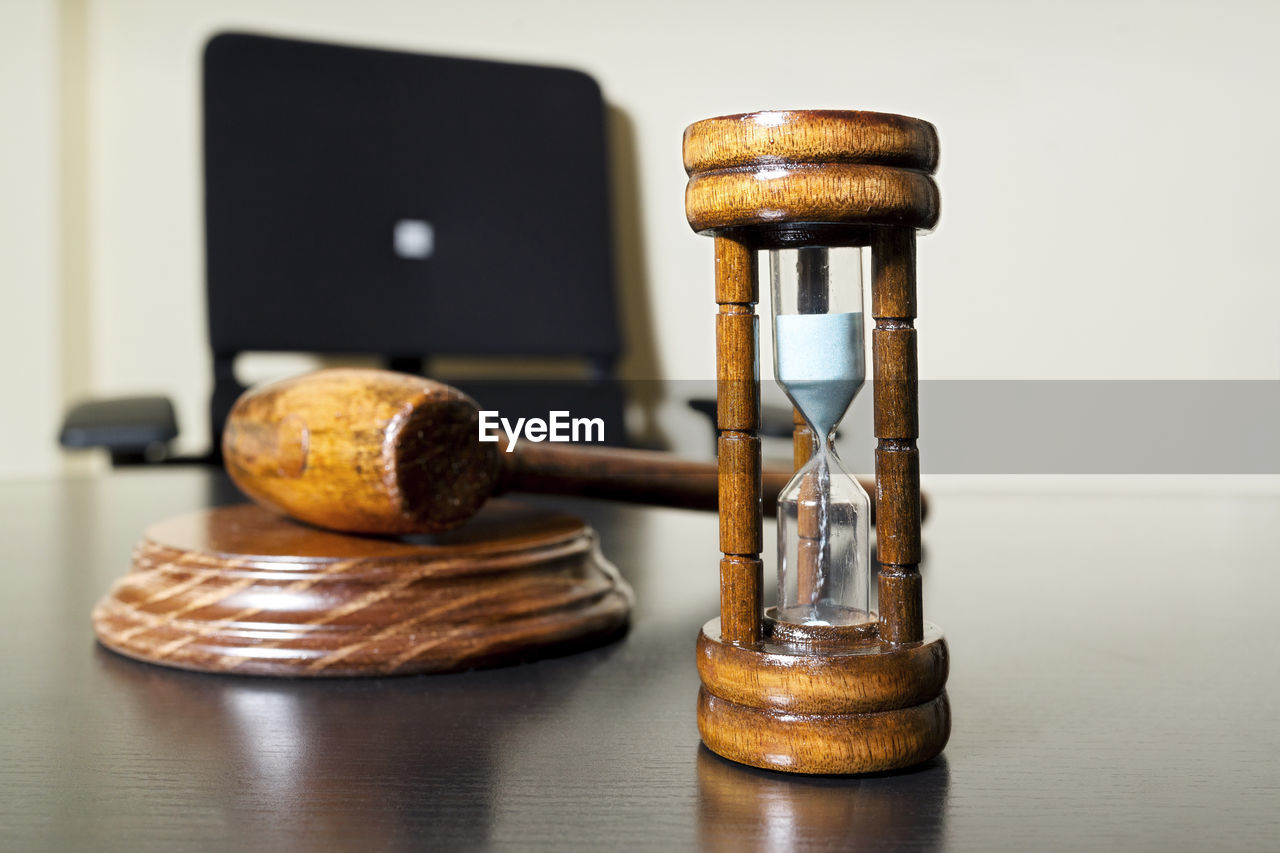 High angle view of gavel with hourglass on wooden table