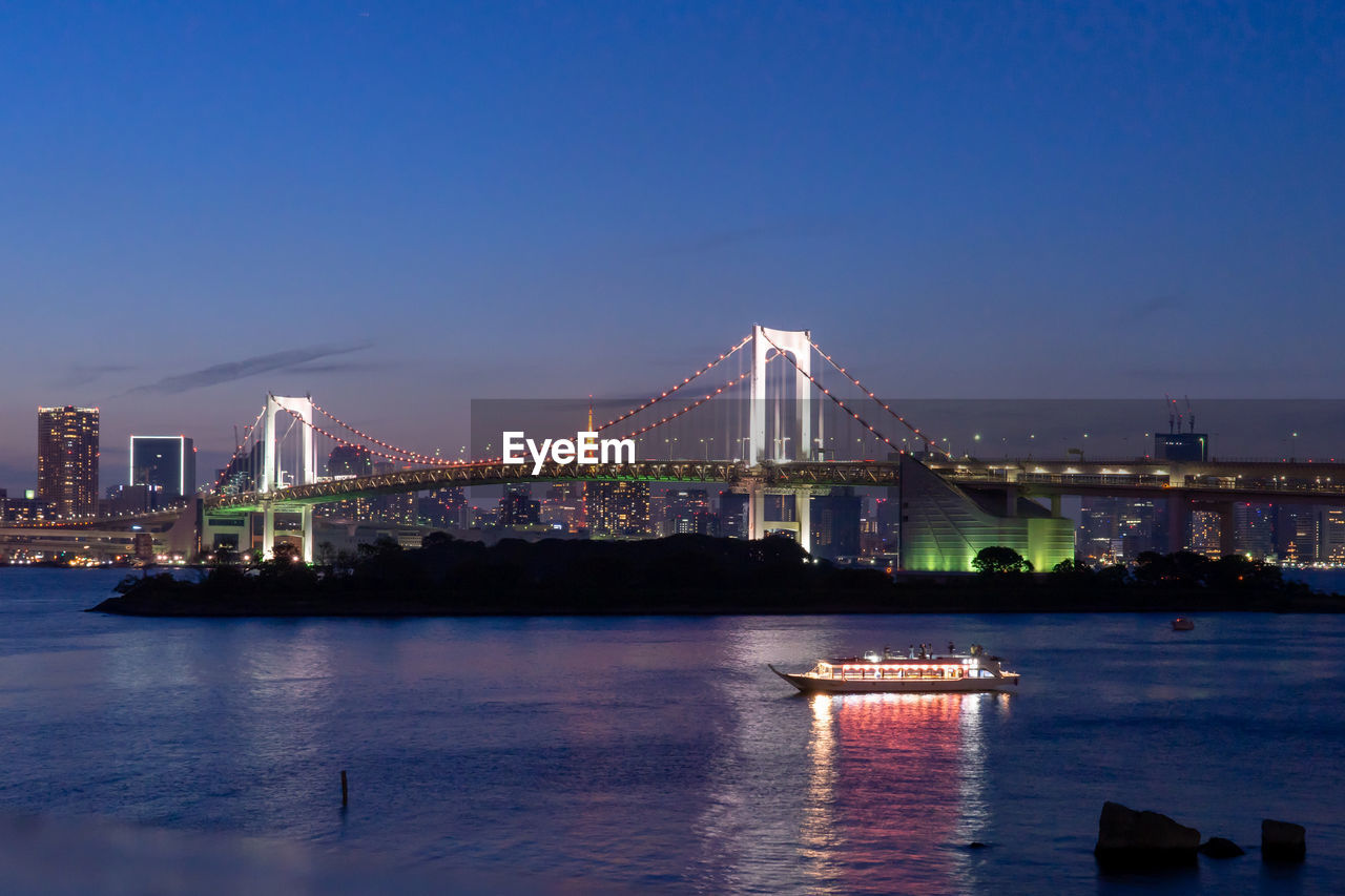 ILLUMINATED BRIDGE OVER RIVER