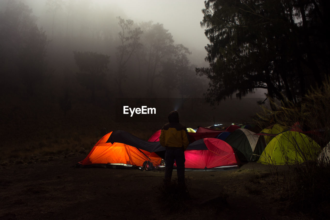 Men enjoy the atmosphere of the forest in the middle of the mountain at night