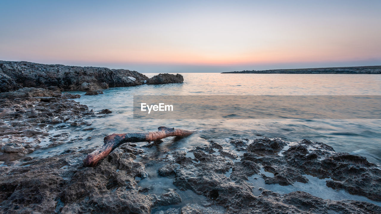 Scenic view of sea against clear sky at sunset