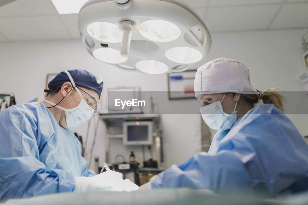 Doctors in uniforms preparing for operation in surgery