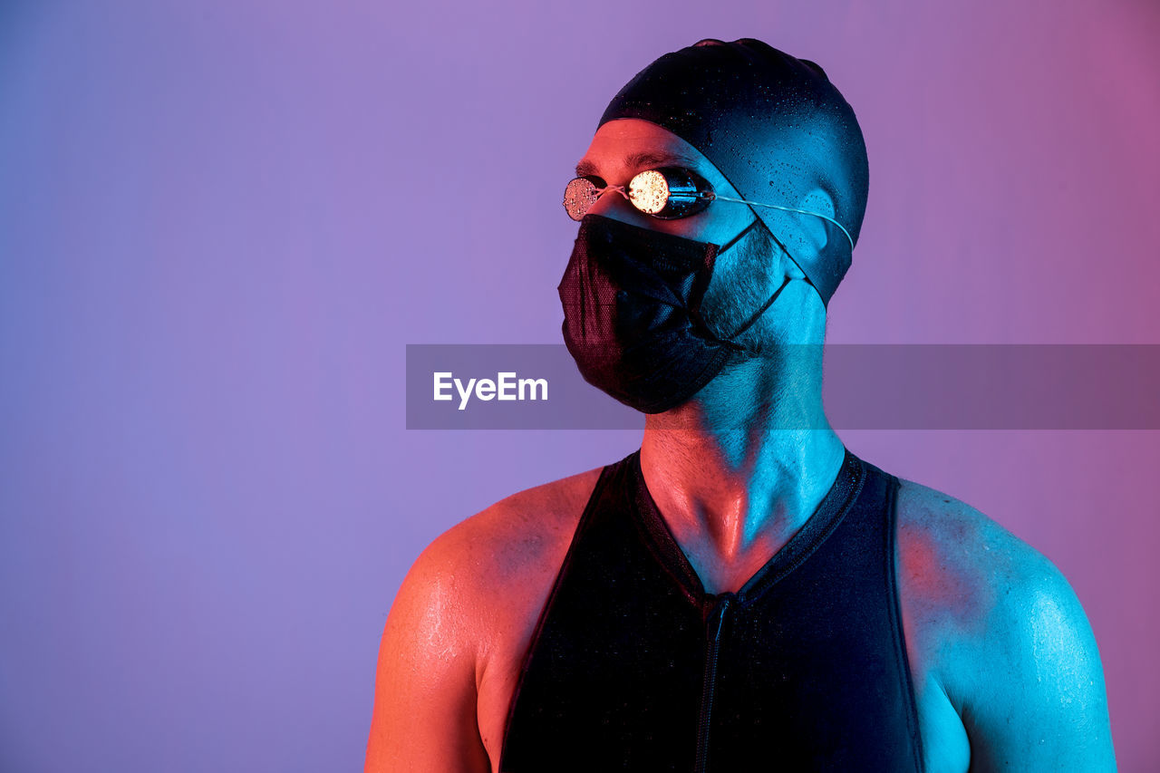 Portrait of a swimmer with mask, cap and goggles looking up