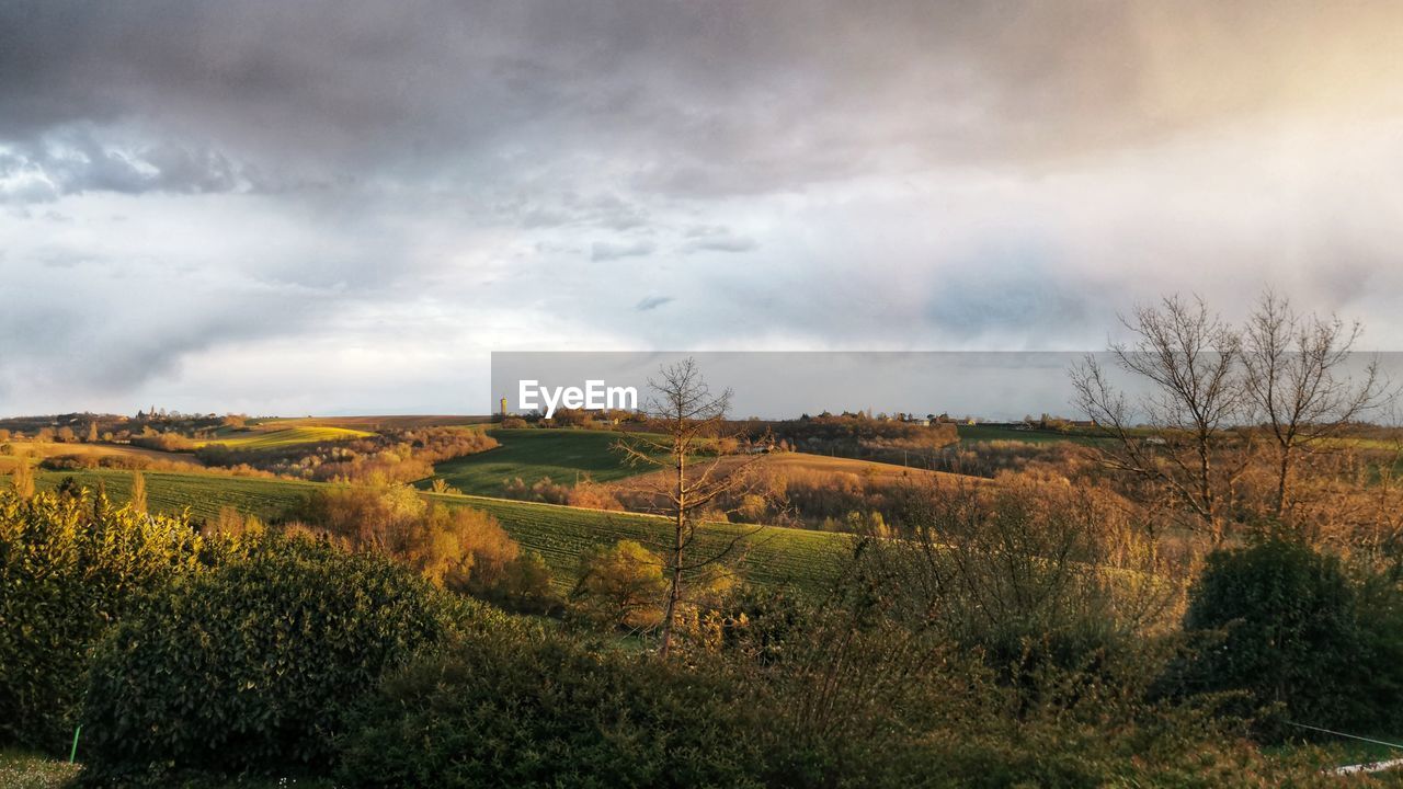 scenic view of field against cloudy sky