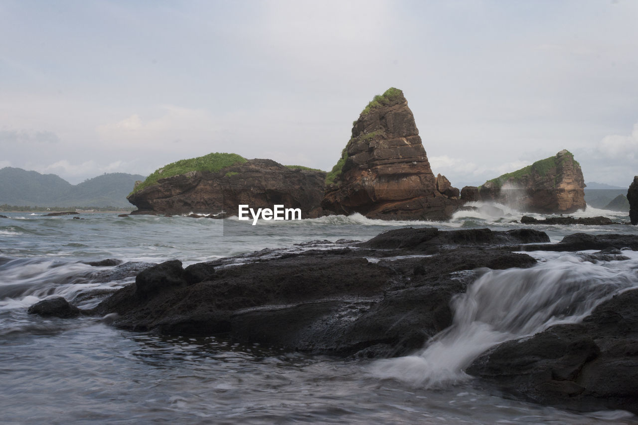 Rocks in sea against sky