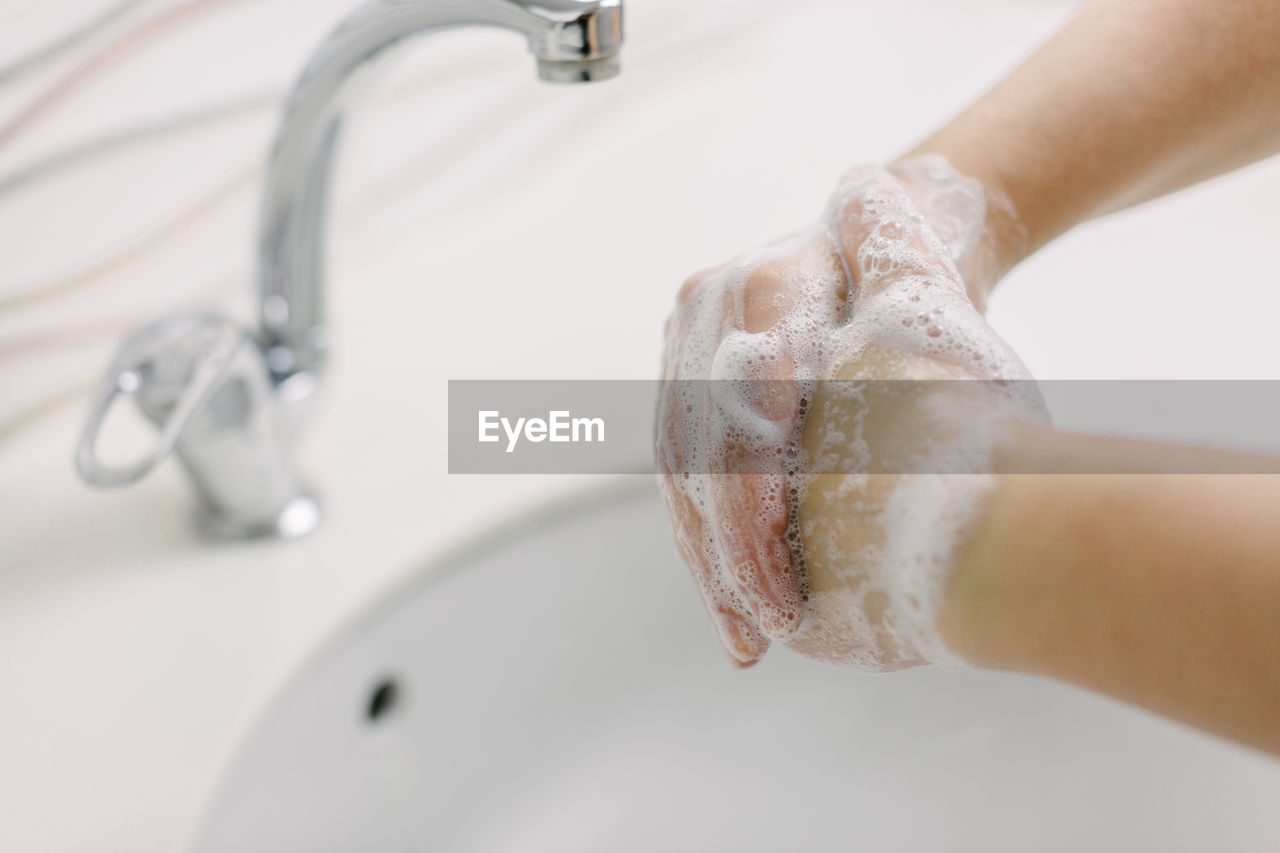 Woman washes her hands by surgical hand washing method.