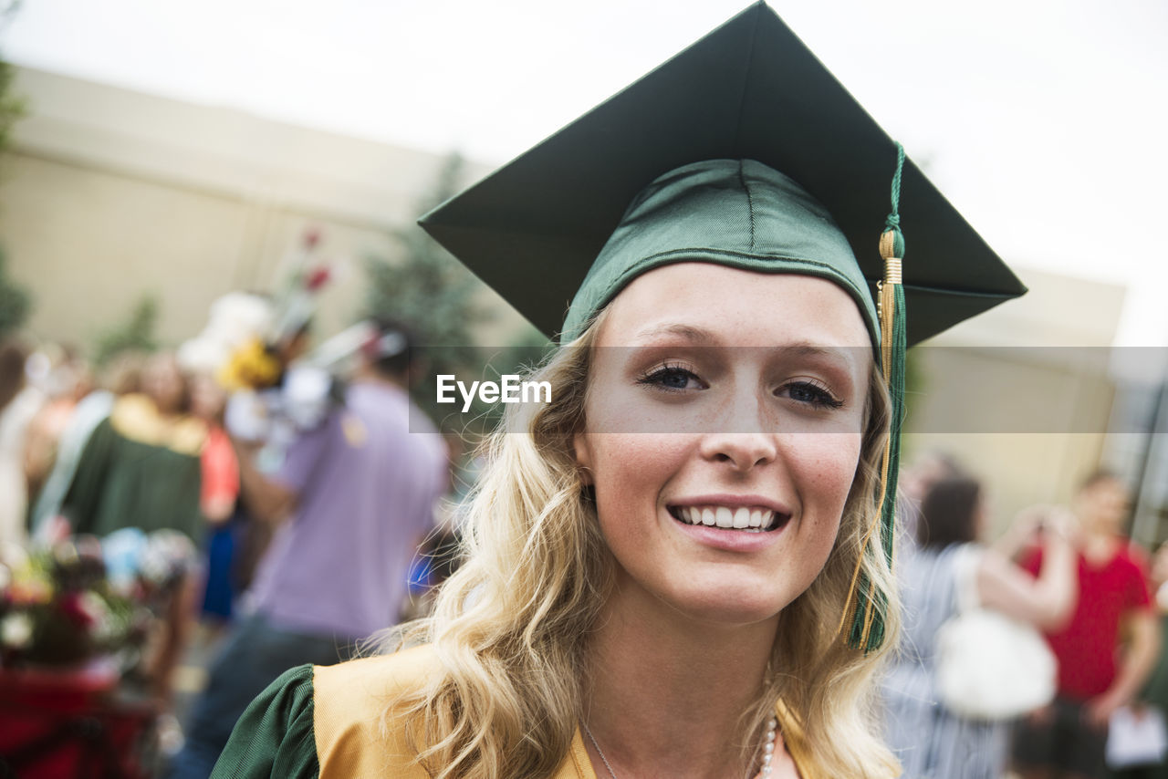 Portrait of woman with mortarboard at graduation ceremony