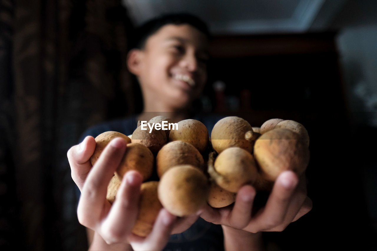 Cute smiling boy holding fruits