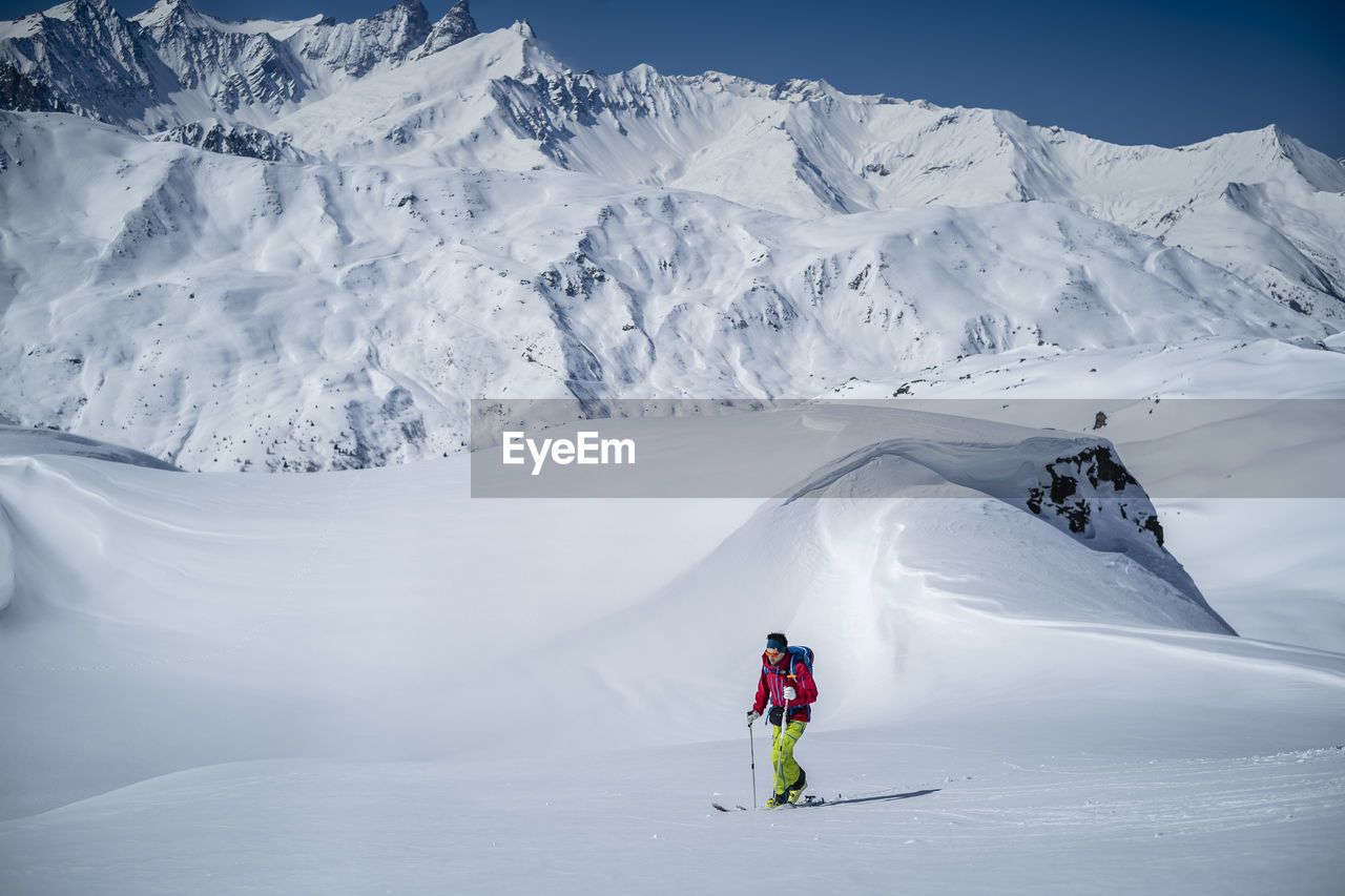 Man skiing on snowcapped mountains during winter