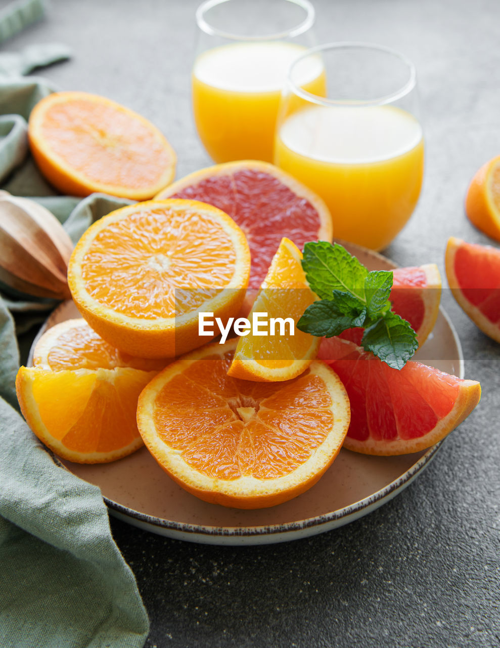Glasses of juice and fresh citrus fruits