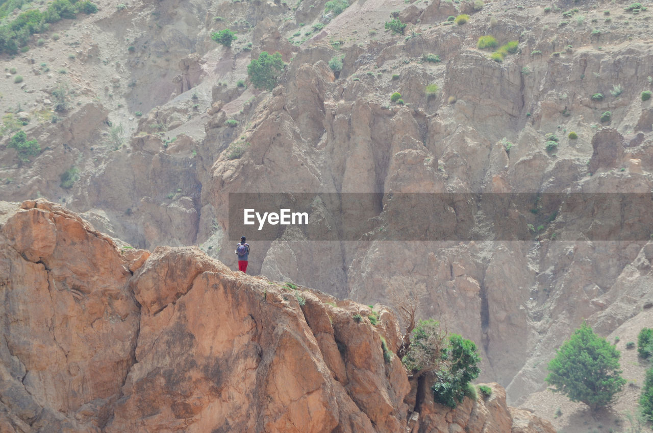 Rear view of man standing against mountains