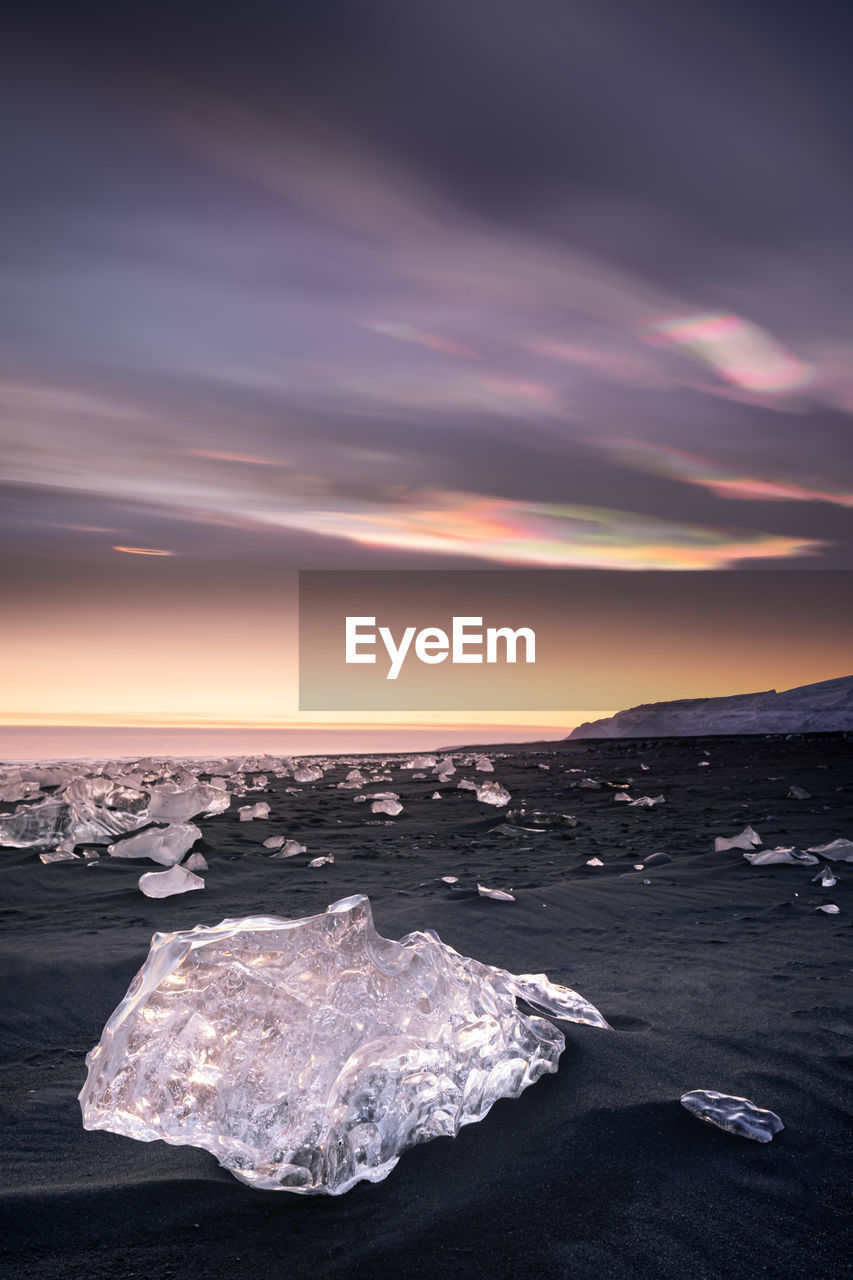 SCENIC VIEW OF FROZEN SEA AGAINST SKY AT SUNSET