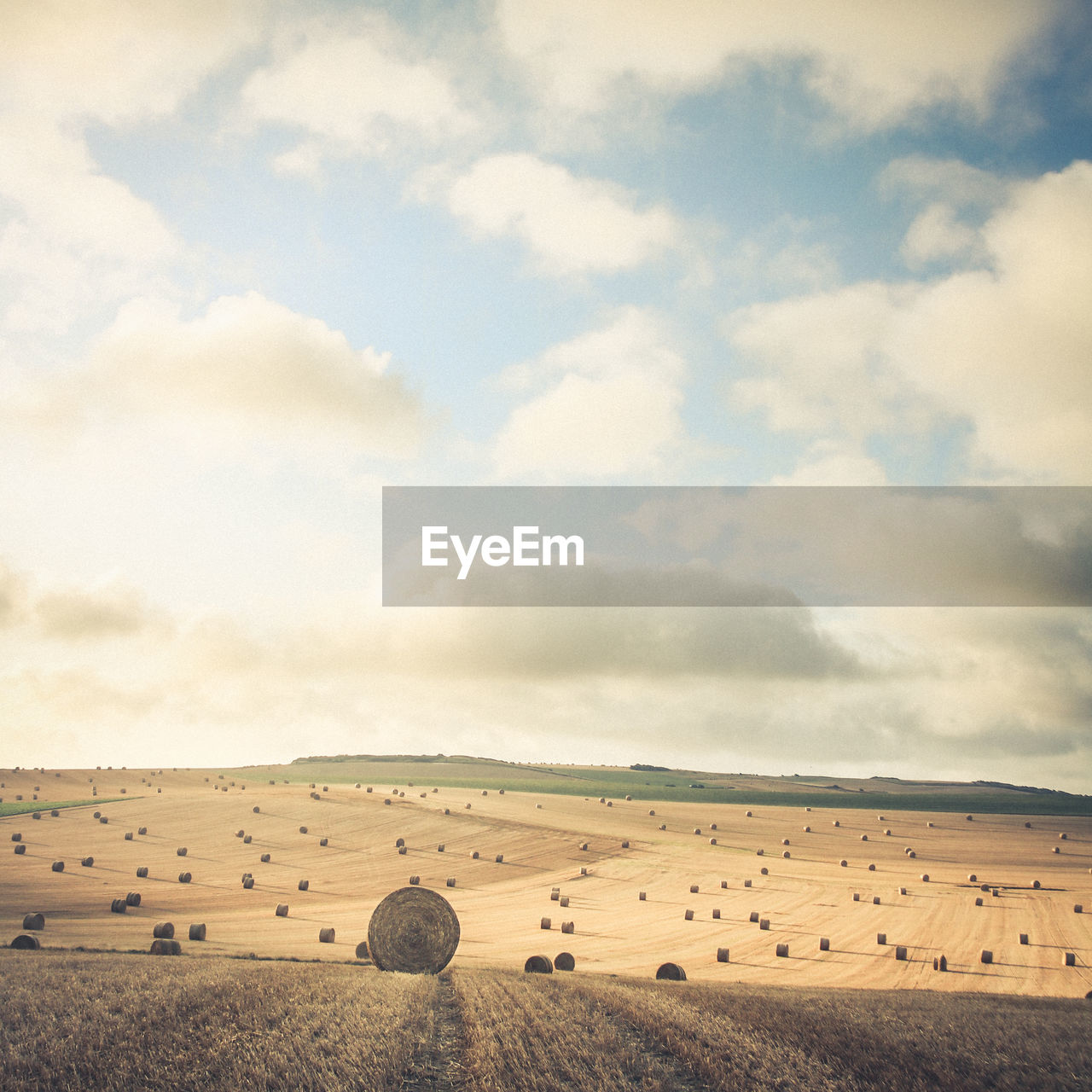 Hay bales on field against sky