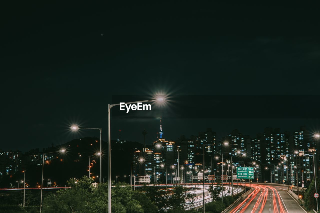 Illuminated city against sky at night