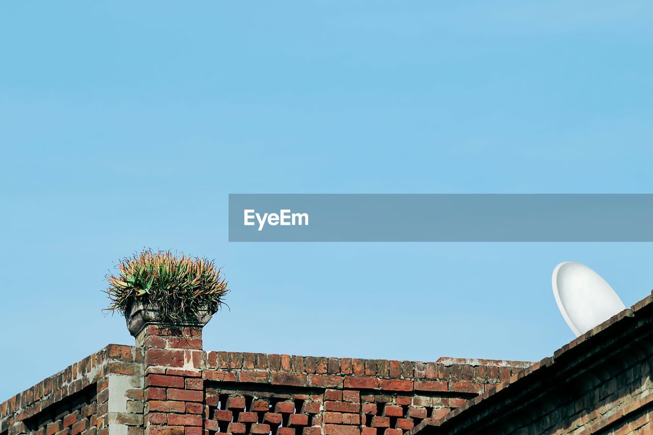 LOW ANGLE VIEW OF ROOF AND BUILDING AGAINST CLEAR SKY