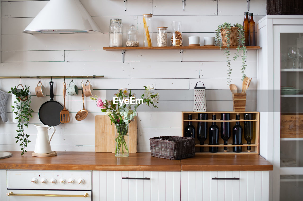 Light cozy wooden kitchen. kitchenware. kitchen interior in apartment. utensils on the wall