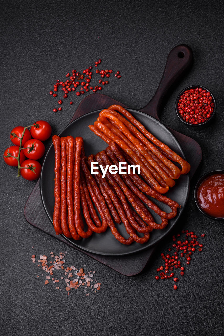 red, food and drink, food, studio shot, freshness, no people, spice, vegetable, meat, chili pepper, healthy eating, indoors, high angle view, fruit, ingredient, kitchen utensil, still life, produce, red meat, gray, strawberry, gray background, wellbeing, directly above, eating utensil, black background, red chili pepper