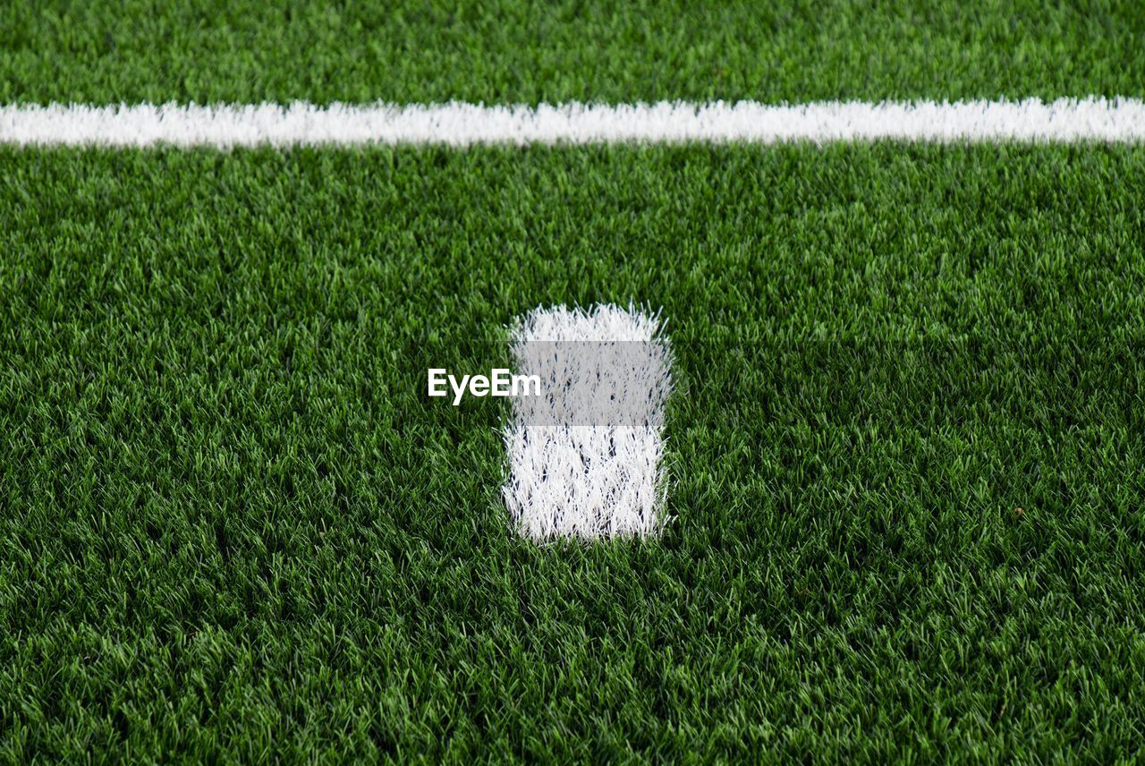 White line on green football field. artifical grass with white paint mark, soccer playfield