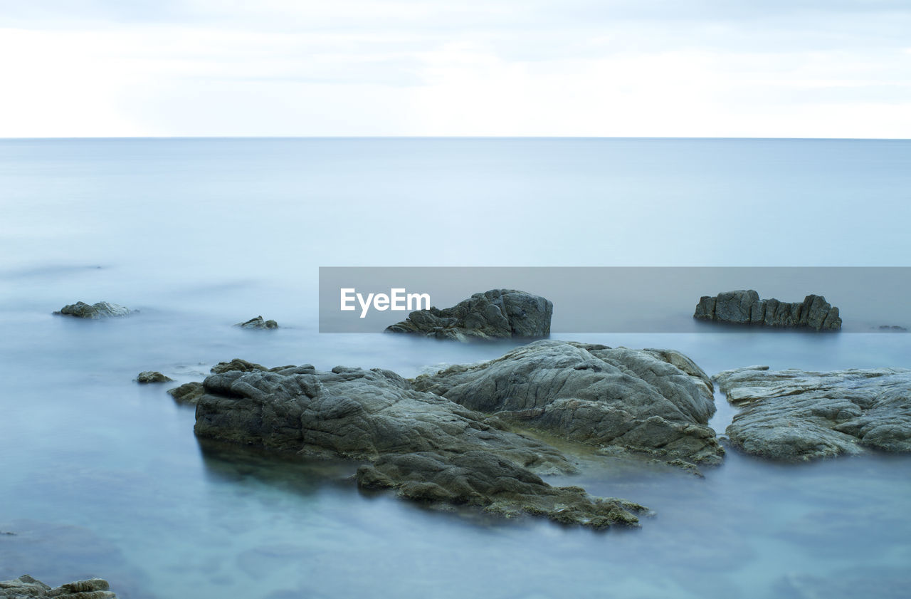 Rocks in sea against sky