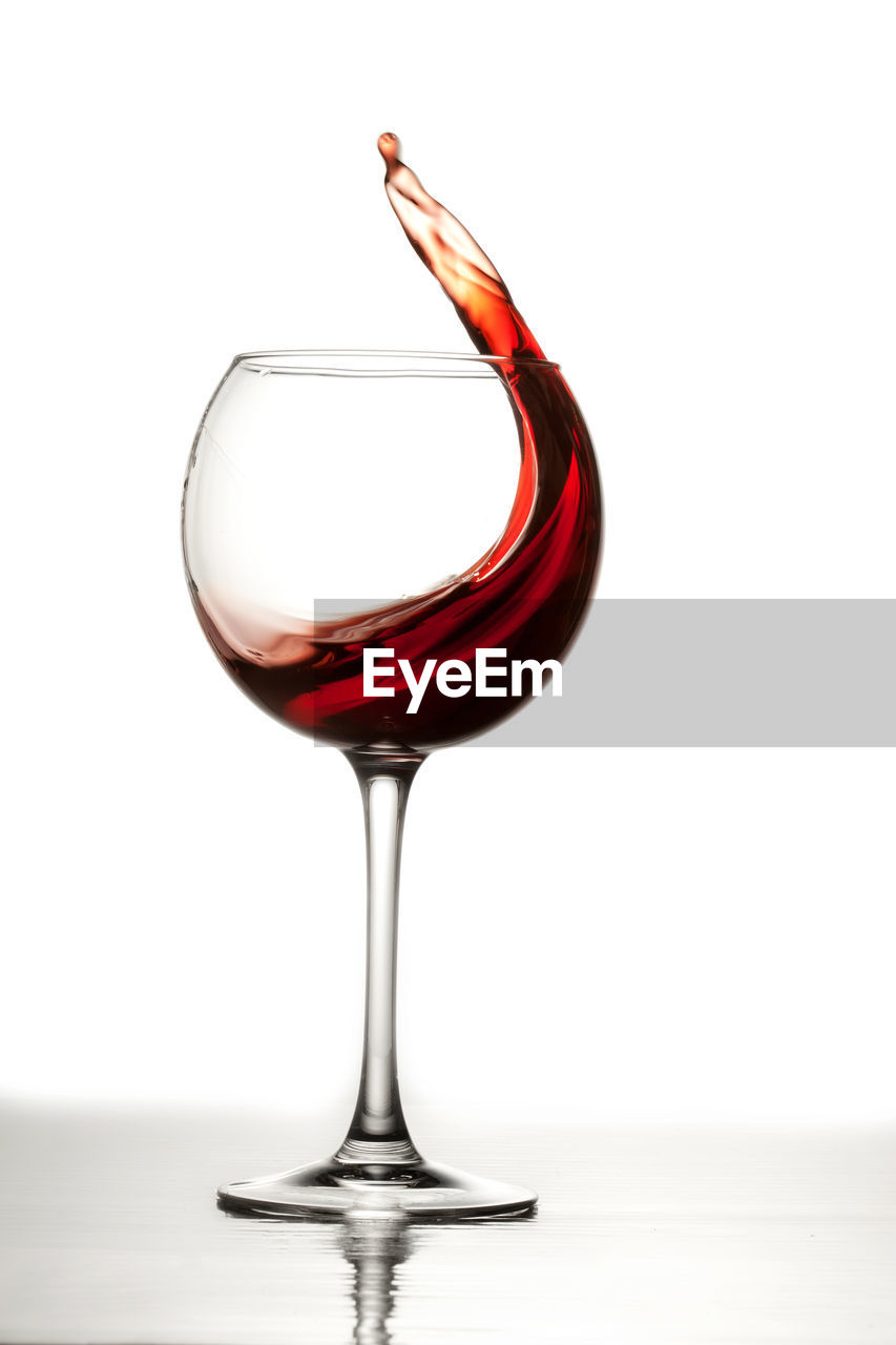 Close-up of wineglass on table against white background