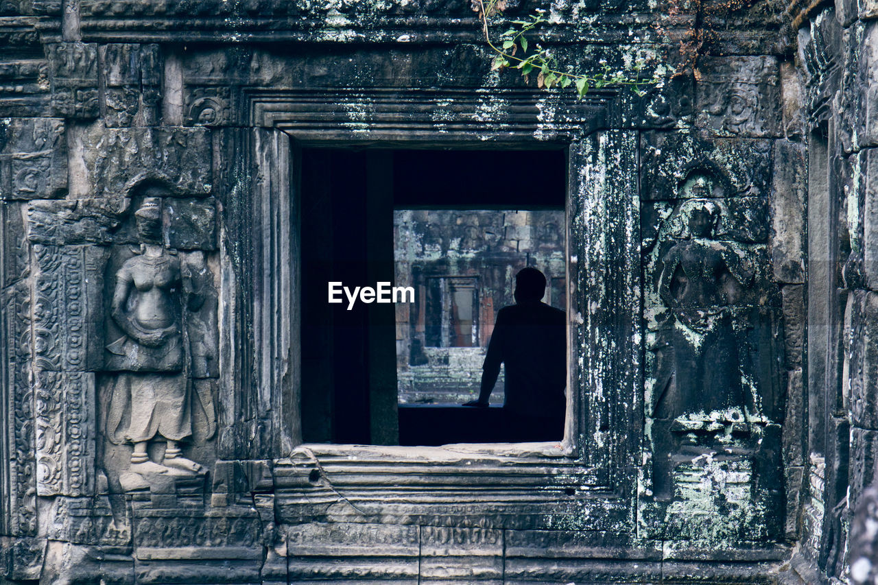 Man seen through old temple window