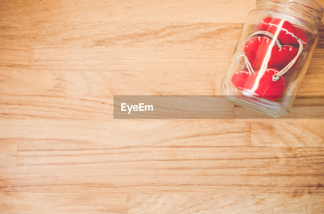 High angle view of heart shape in jar on hardwood floor