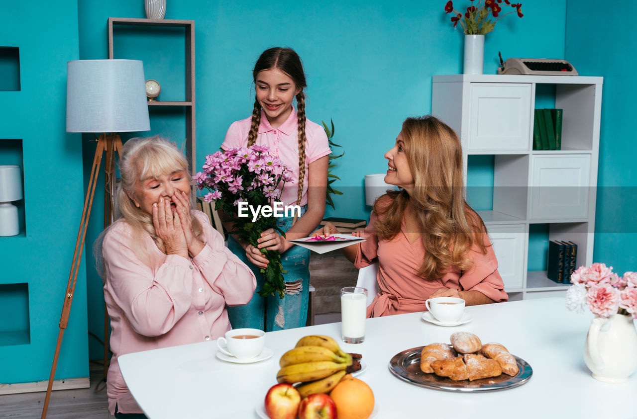 Cute girl giving flowers to grandmother