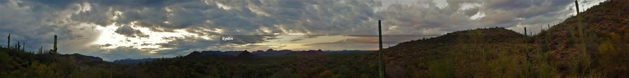 SCENIC VIEW OF MOUNTAINS AGAINST CLOUDY SKY