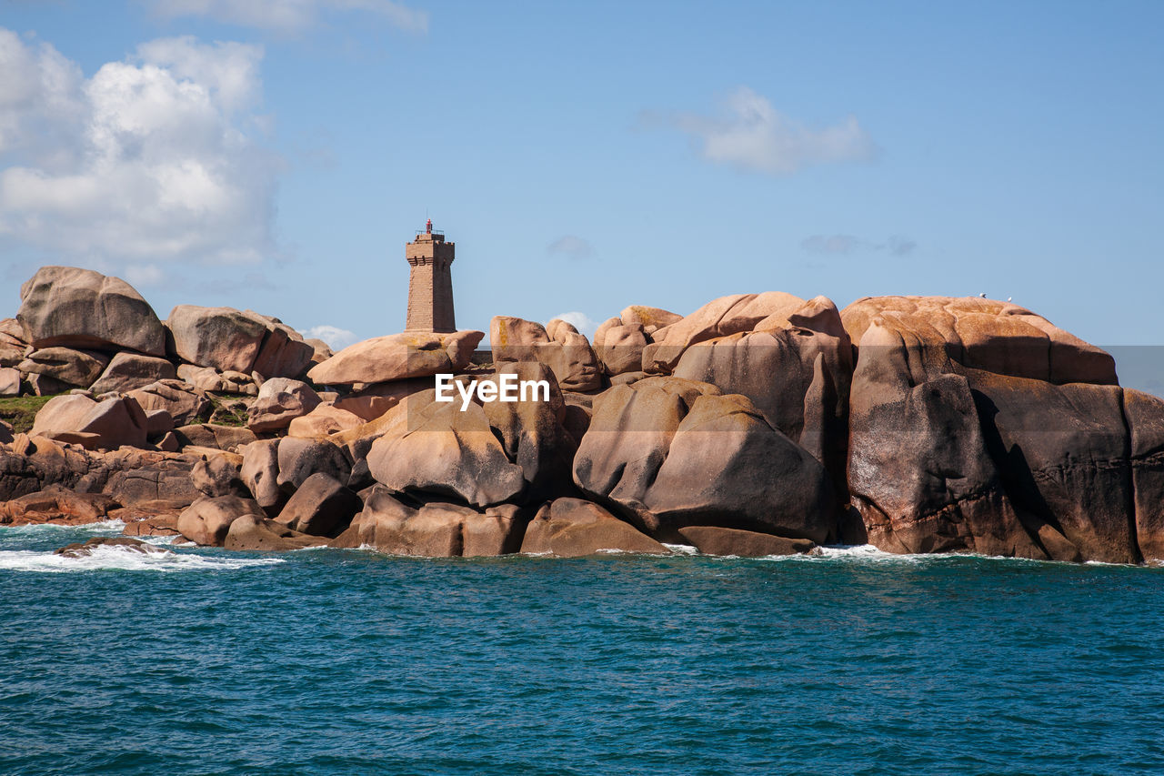 Lighthouse amongst pink granite boulders, ploumanach coast, brittany, france