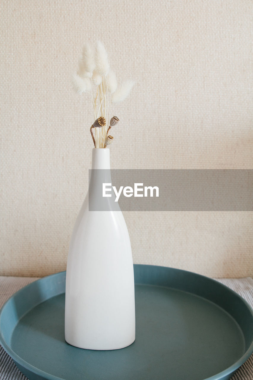 CLOSE-UP OF WHITE FLOWER VASE ON TABLE AT HOME