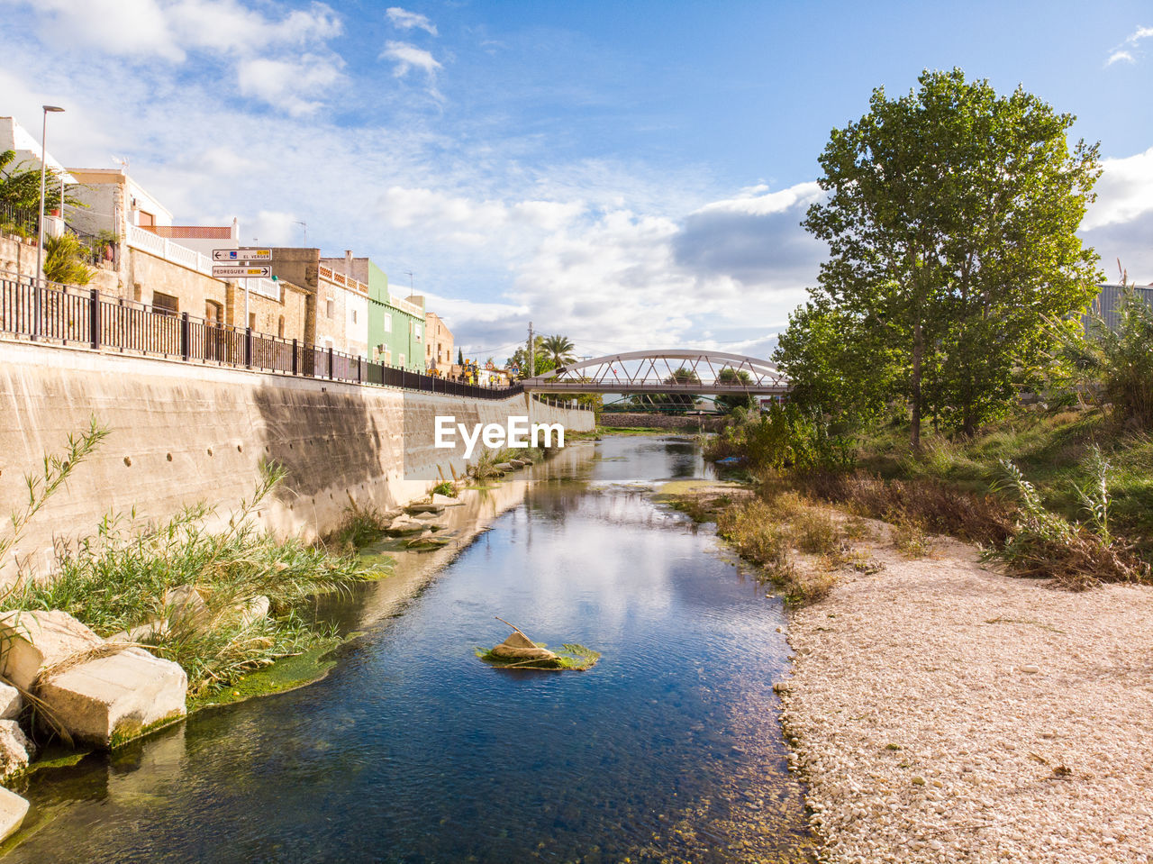 Scenic view of river by buildings against sky