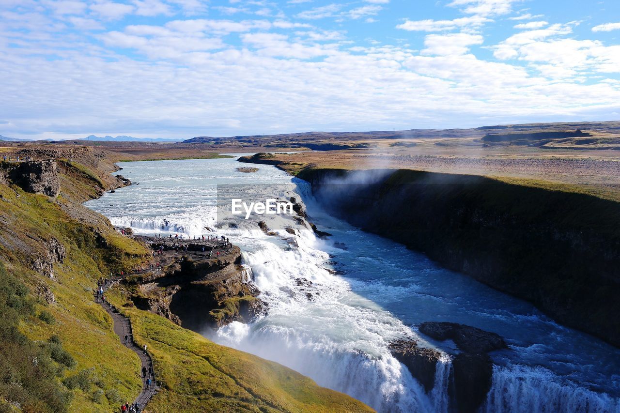 View of river in iceland against cloudy sky