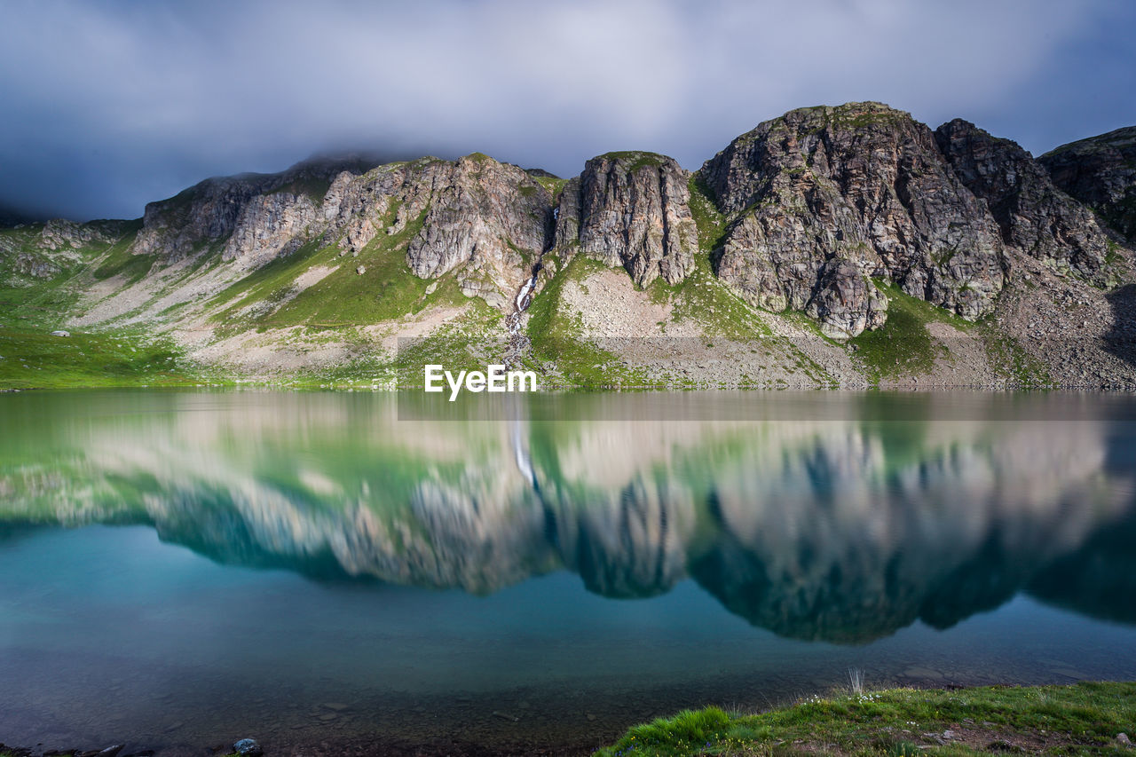 Reflection of mountains against sky on lake at gran paradiso national park