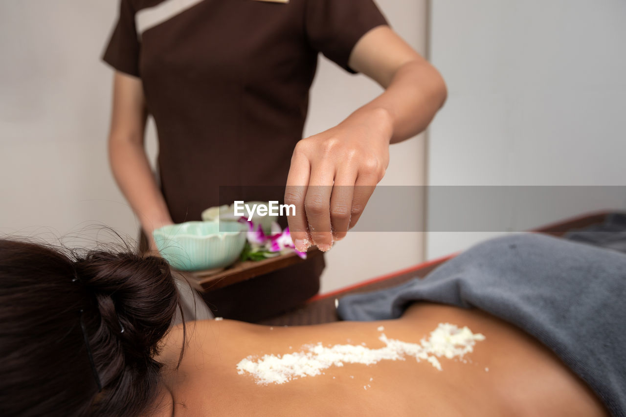 adult, women, indoors, body care, food, young adult, relaxation, wellbeing, beauty spa, food and drink, human leg, lifestyles, clothing, two people, beauty treatment, person, female, spa treatment, skin, lying down, domestic room, limb, midsection, health spa, massaging, holding, brown hair, freshness, hand, human skin, rear view, human face, human hair