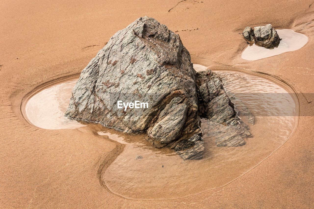 HIGH ANGLE VIEW OF ROCK ON SAND DUNE