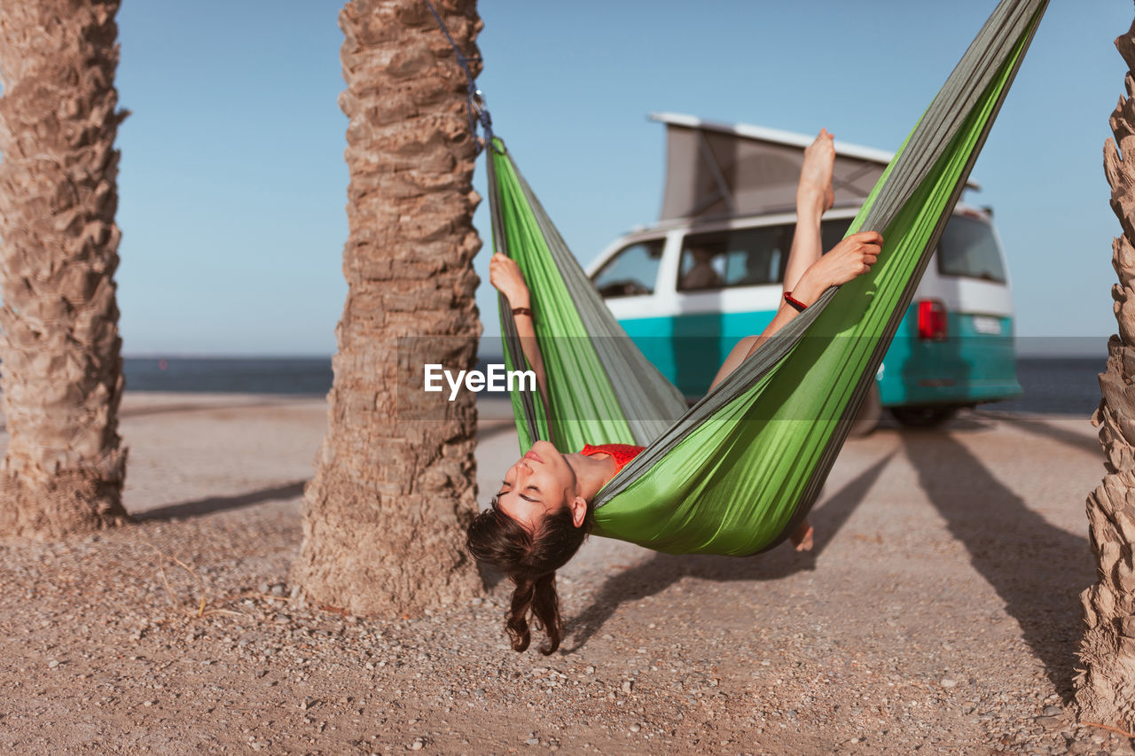 Woman relaxing on hammock at beach