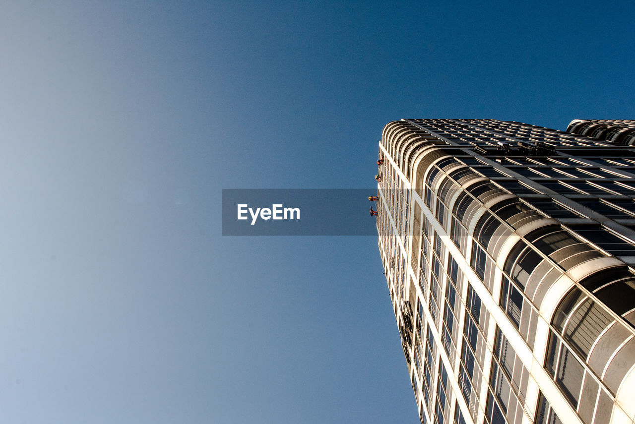 Low angle view of skyscraper against clear blue sky