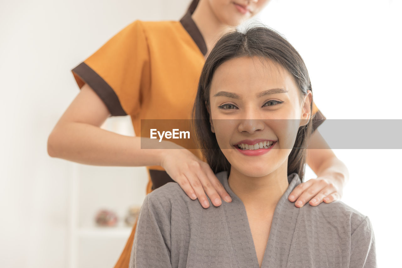 In a spa salon, a young woman enjoys massage therapy.