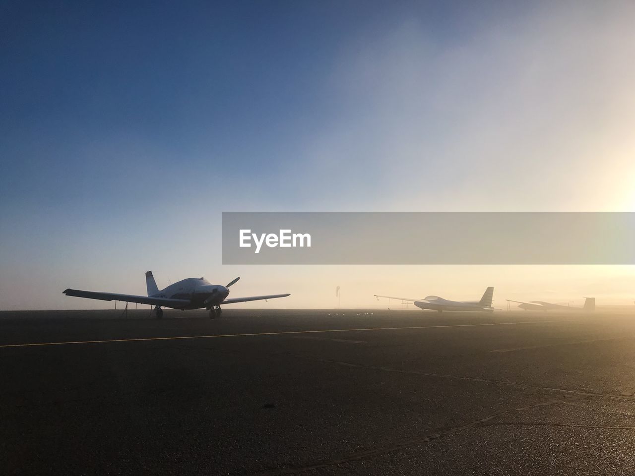 AIRPLANE FLYING OVER RUNWAY AGAINST SKY