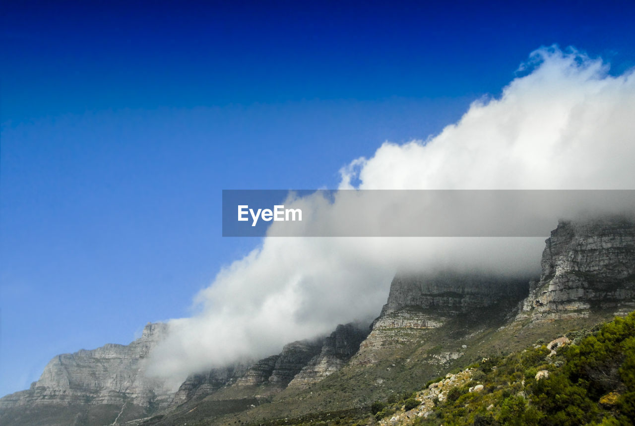 Low angle view of mountains against blue sky