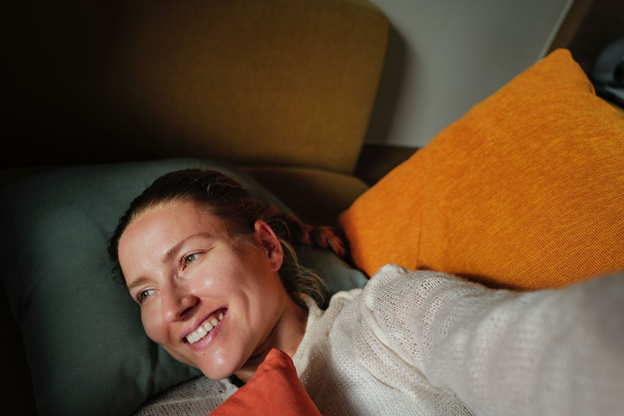 Woman relaxing on the colorful pillows smiling