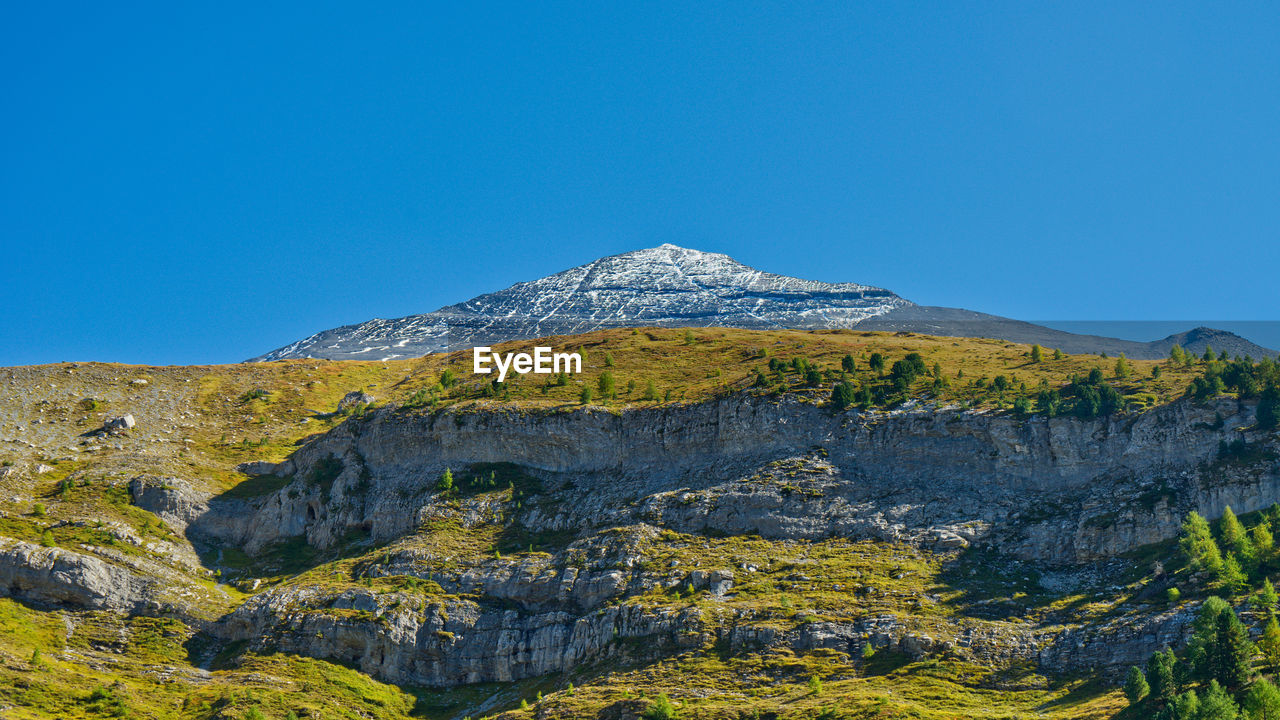 Low angle view of mountain against blue sky