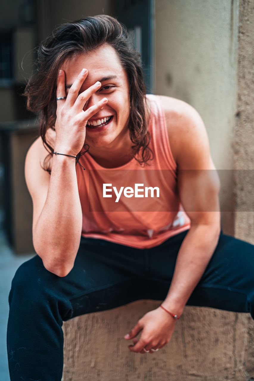 Portrait of young man smiling while sitting on seat