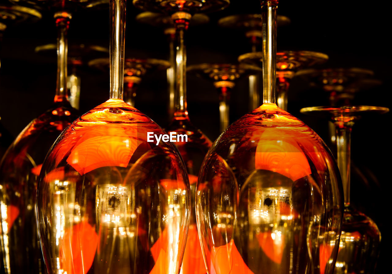 CLOSE-UP OF WINE GLASSES ON BAR COUNTER AT NIGHT