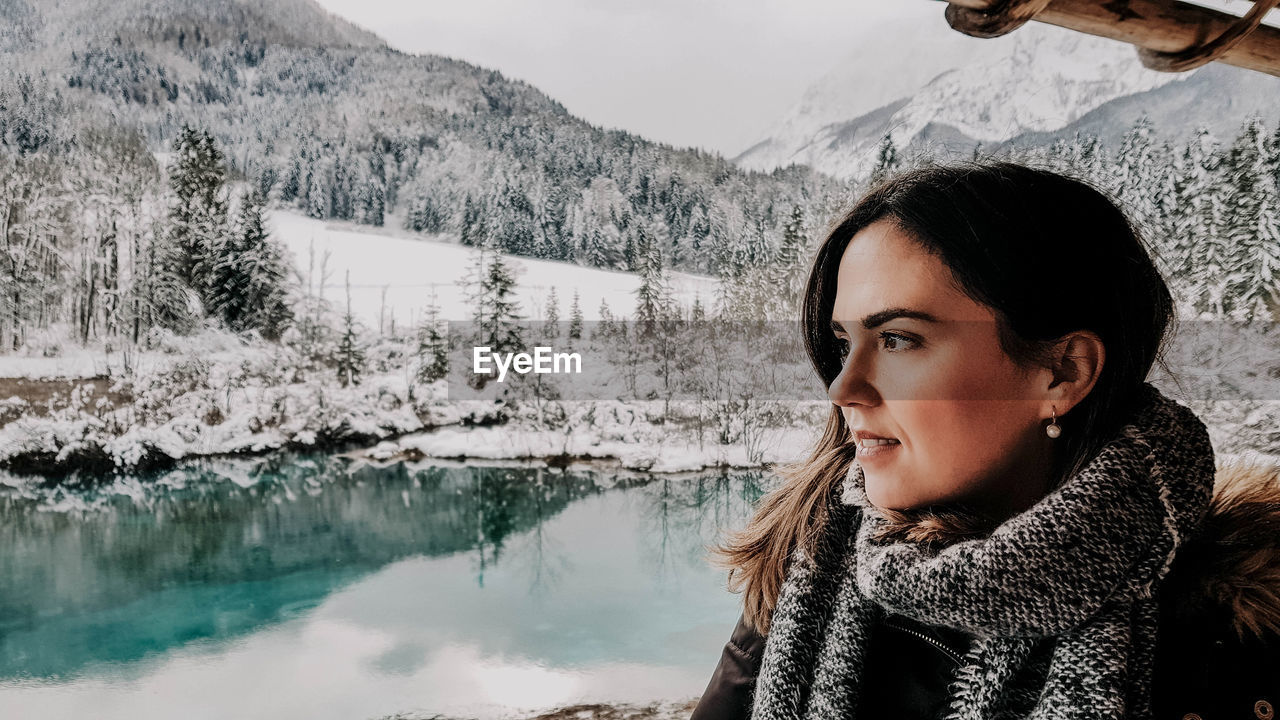 Portrait of young woman at beautiful lake in winter. mountains, snow. zelenci, slovenia.