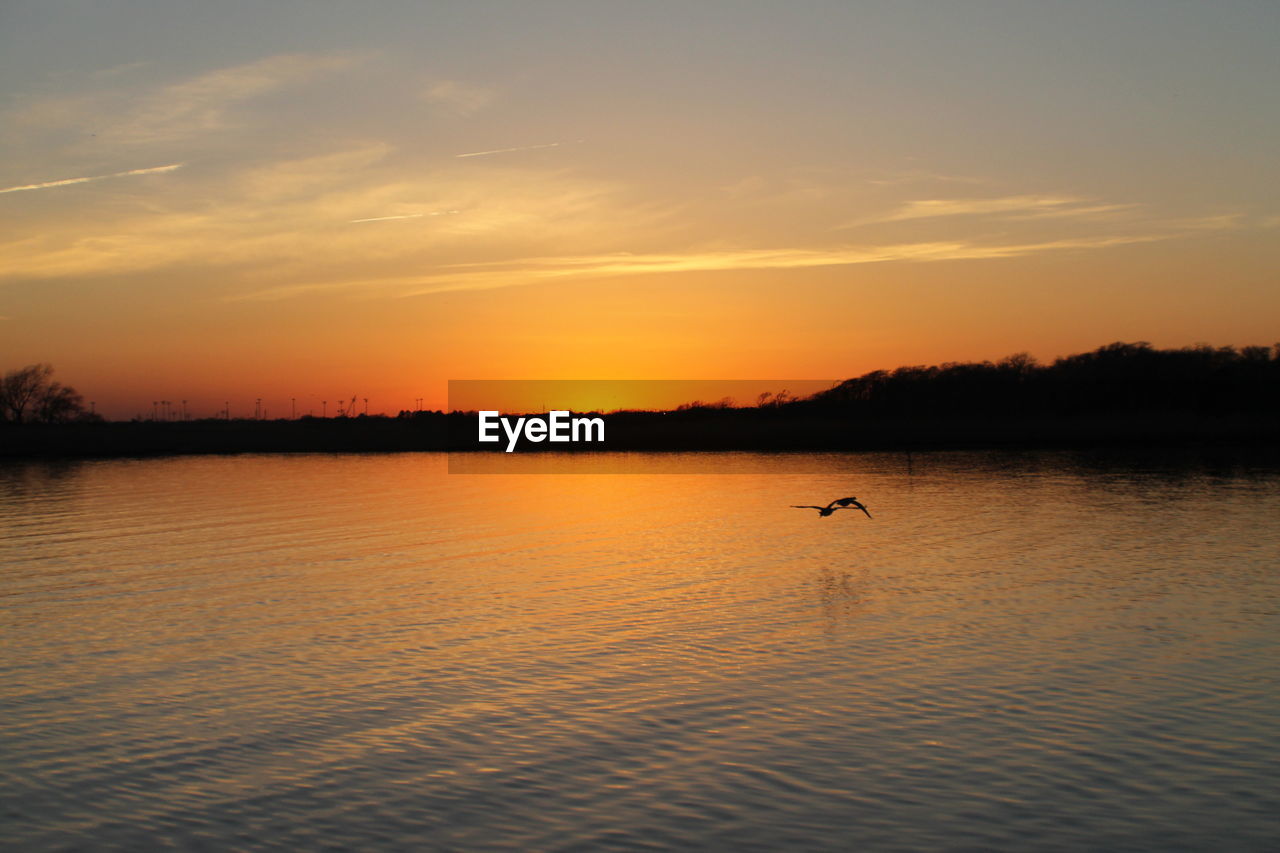 Scenic view of lake against sky during sunset