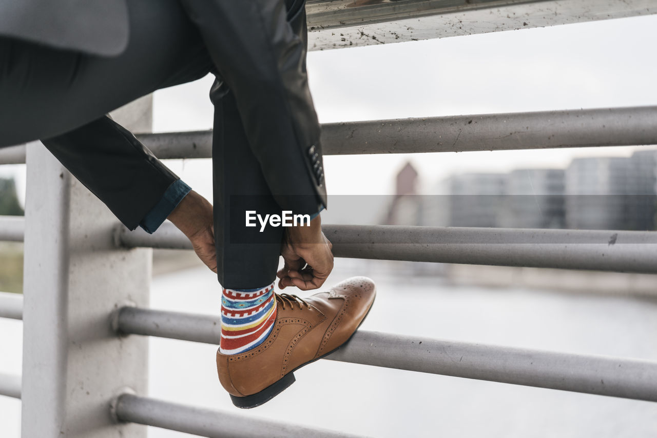 Young businessman tying shoe laces