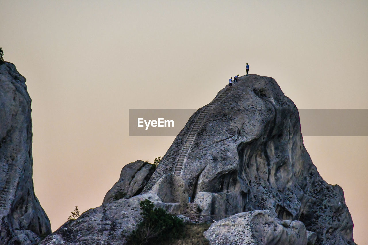 Low angle view of rock formations on mountain against clear sky