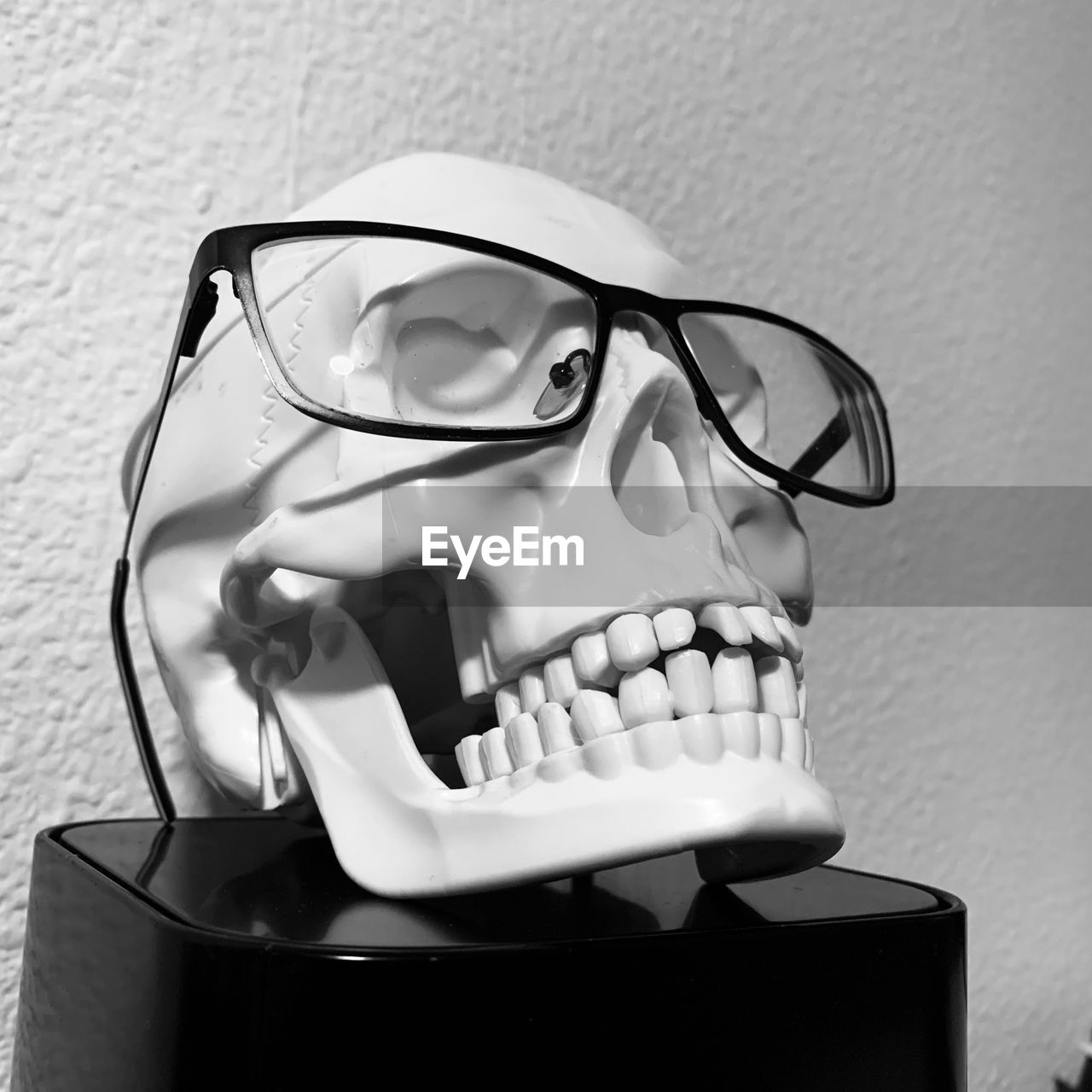 Close-up of eyeglasses with human skull on table