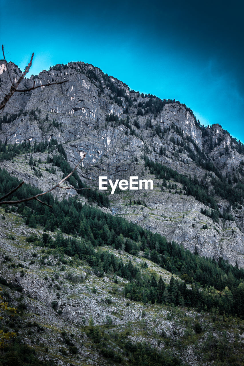 Scenic view of mountains against blue sky