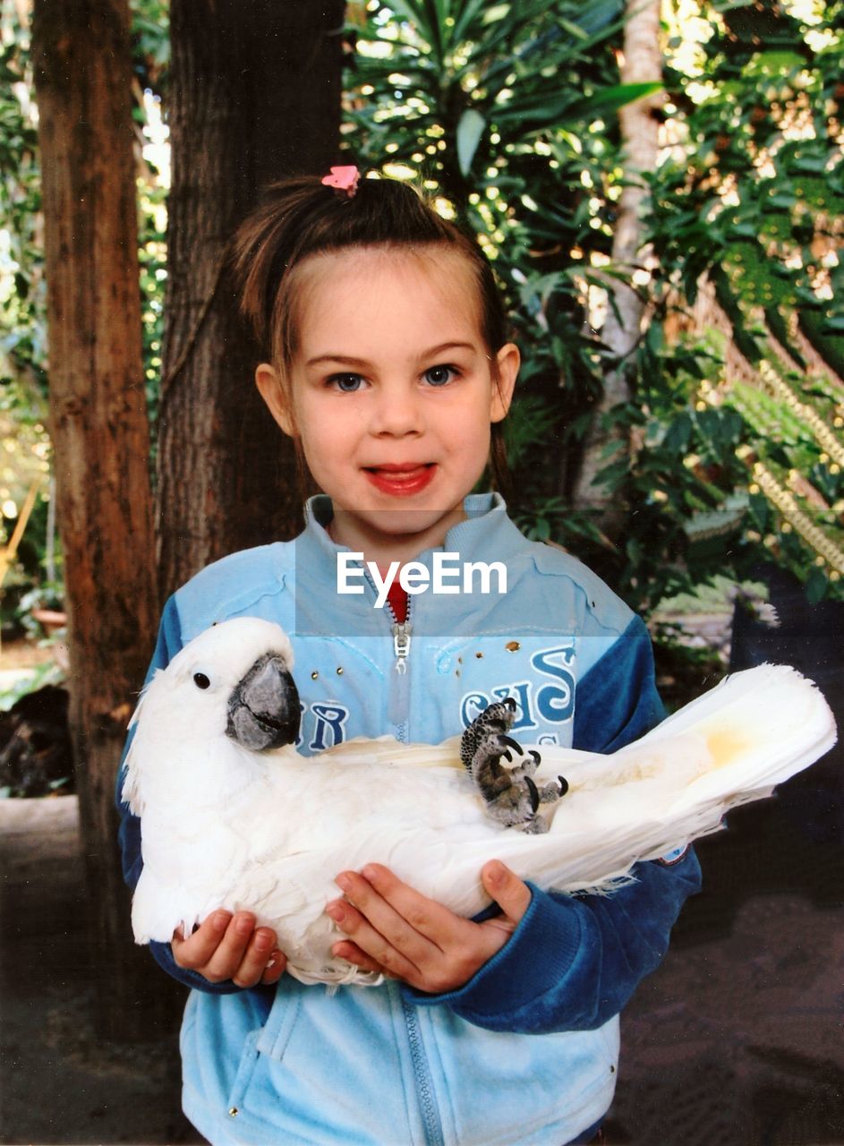 Portrait of girl holding bird